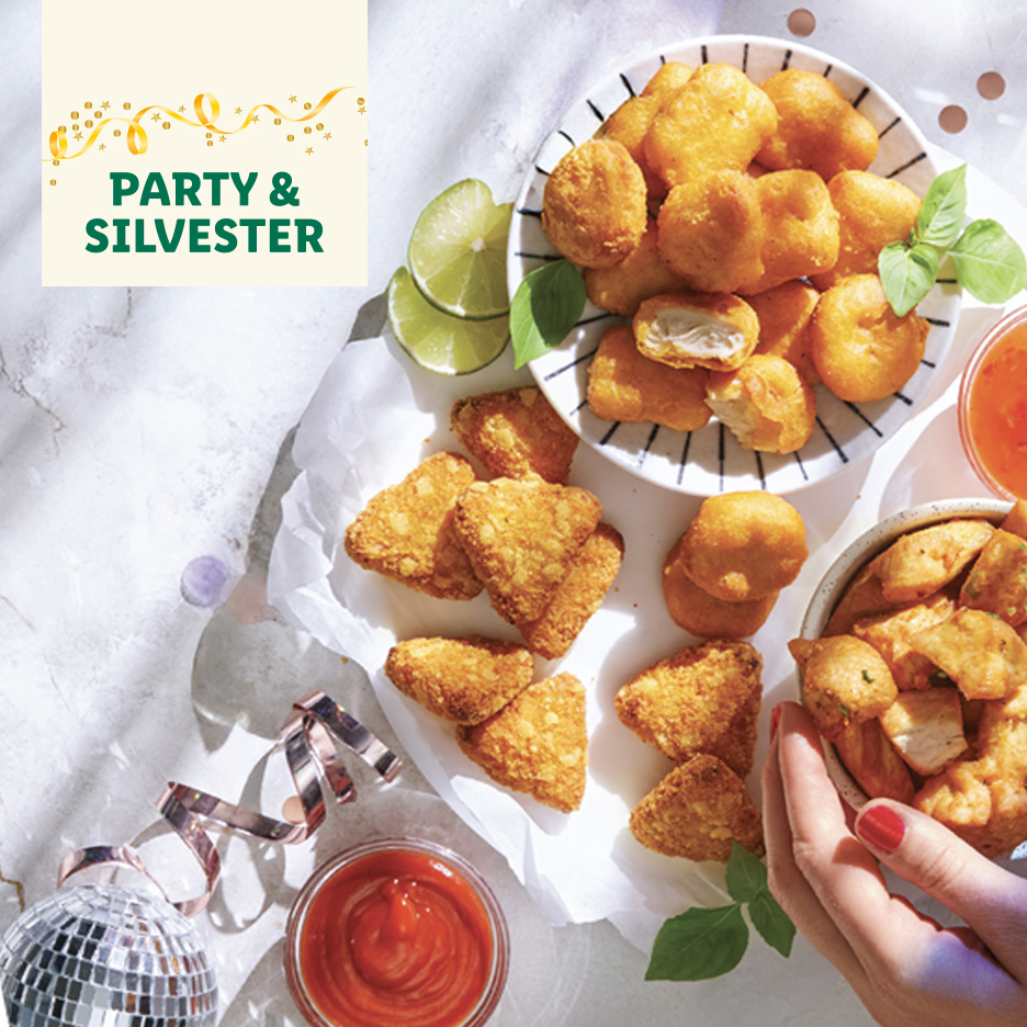 Raznovrsna pržena hrana za zabavu i Silvester, uključujući nagetse i trouglaste zalogaje.