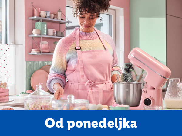 Žena u kuhinji sa ružičastim mikserom i slatkišima.