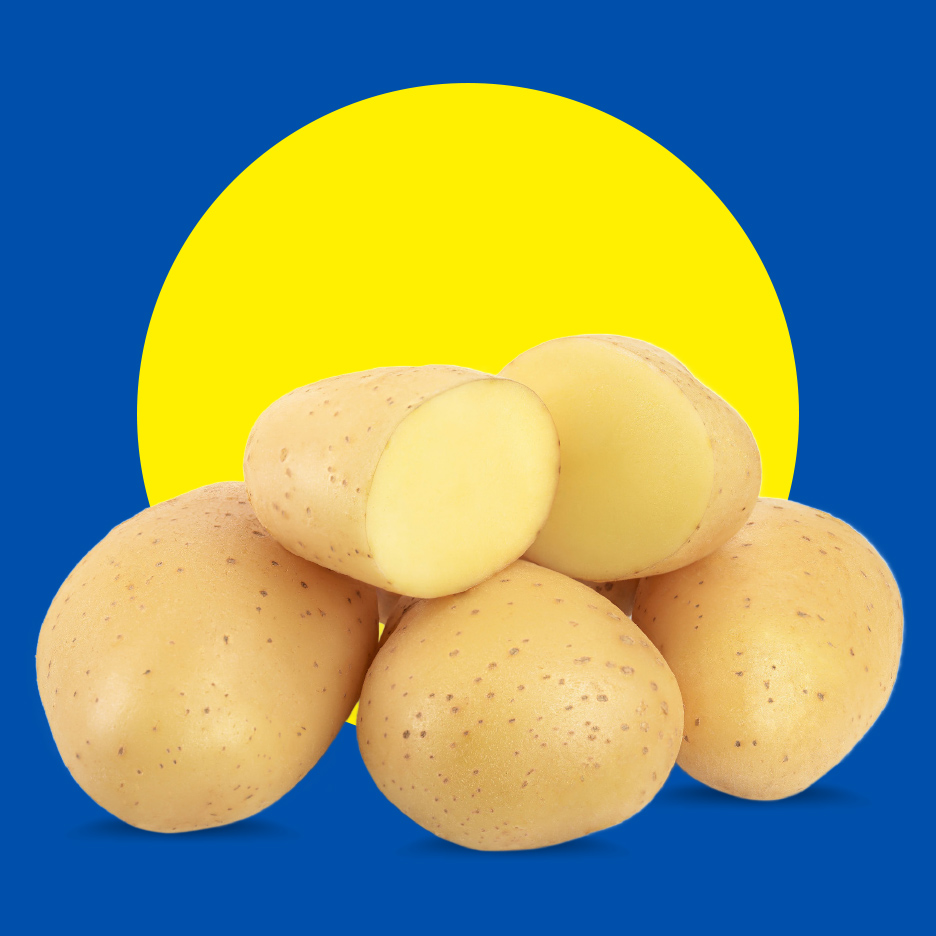 Sveži krompiri, neki prepolovljeni, na plavoj pozadini sa žutim krugom.
