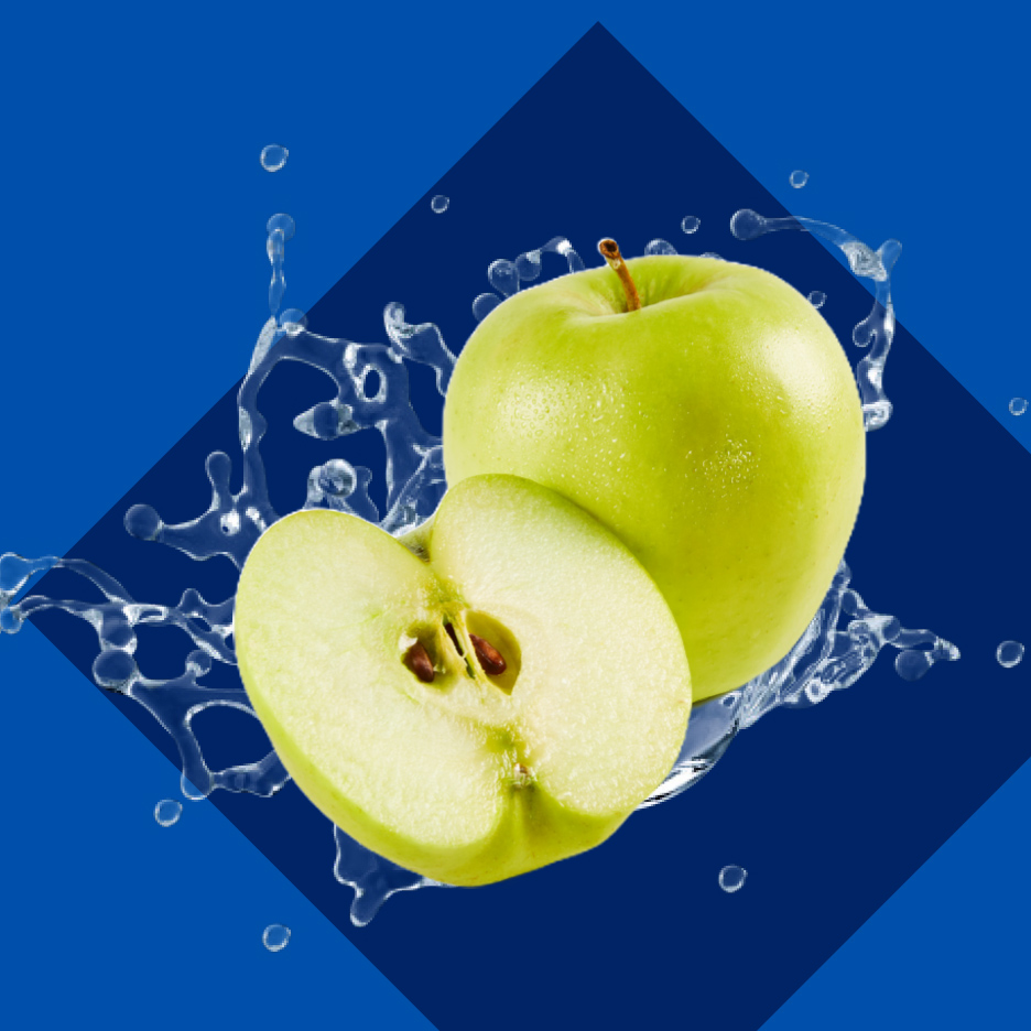 Zelena jabuka i pola jabuke sa prskanjem vode na plavoj pozadini.