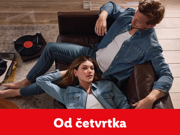 Muškarac i žena u džinsu opuštaju se u dnevnoj sobi sa gramofonom.