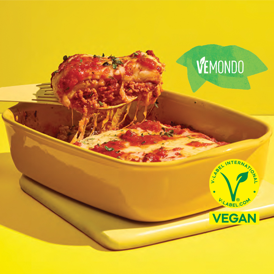 Veganska lazanja sa sirom i paradajz sosom u žutoj posudi za pečenje.